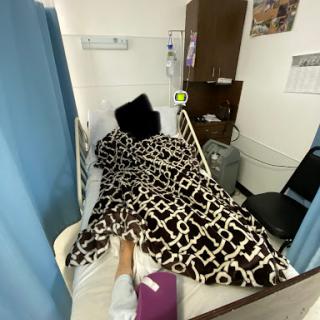 A hospital room showing a patient resting in bed, surrounded by curtains for privacy.