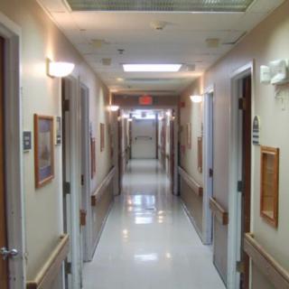 A long hallway in a hospital with doors on each side.