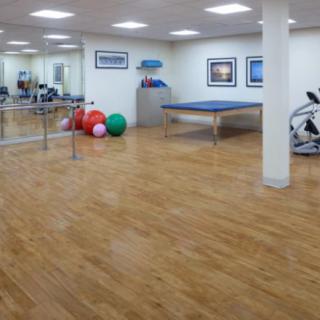 An empty gym with exercise equipment and a ping pong table.