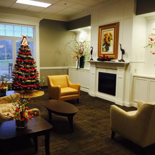 A cozy living room decorated for the holidays with a Christmas tree and fireplace.