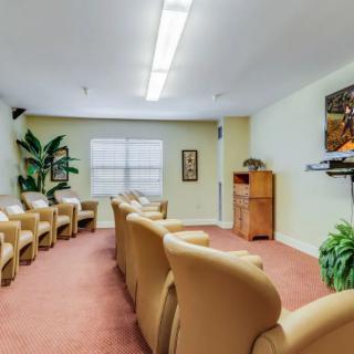 A comfortable waiting room with seating and a TV.