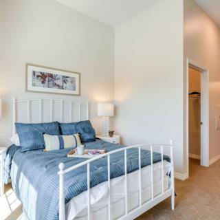 A modern and cozy bedroom with a minimalist design, featuring a neatly made bed with blue bedding and subtle decor.