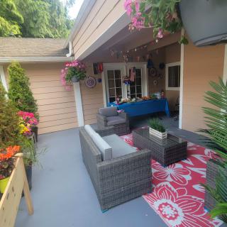 A cozy outdoor patio setup with comfortable seating, vibrant plants, and decorative accents.