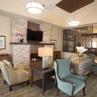 A modern living room interior featuring a fireplace, comfortable seating, and elegant decor.