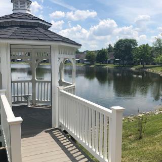 A serene gazebo by the lake on a sunny day.