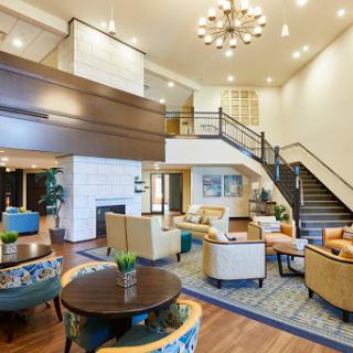 A contemporary lobby with stylish seating and an elegant staircase.