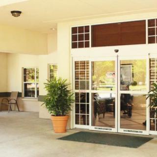 The entrance of a building with glass doors and potted plants.
