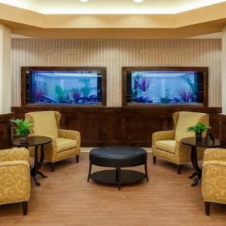 A cozy lobby area featuring comfortable armchairs and twin aquariums.