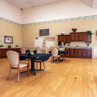 A spacious kitchen and seating area with wooden cabinets and a polished floor.