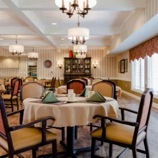 An elegant dining room with neatly arranged tables and chandeliers.