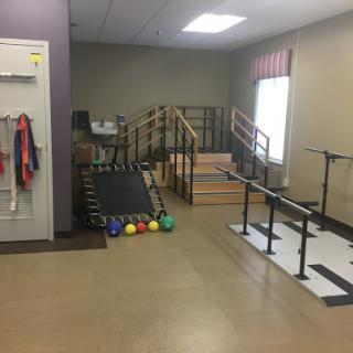 A well-equipped physical therapy space featuring exercise apparatus and rehabilitation tools.