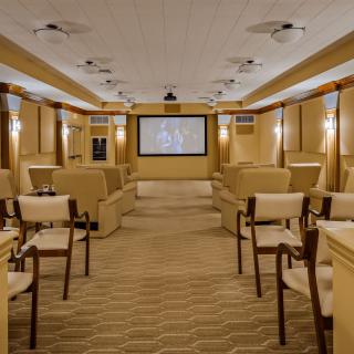 A luxurious home theater with plush seating and a large screen.
