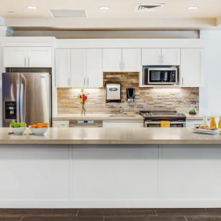 A modern kitchen with white cabinetry, stainless steel appliances, and a stylish backsplash.