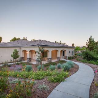 A beautiful house with a landscaped garden and a winding pathway.