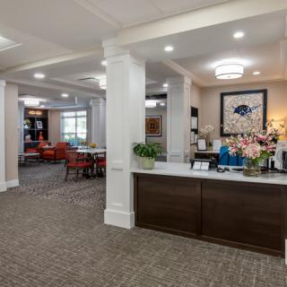 A modern lobby with a reception desk, seating area, and decorative elements.