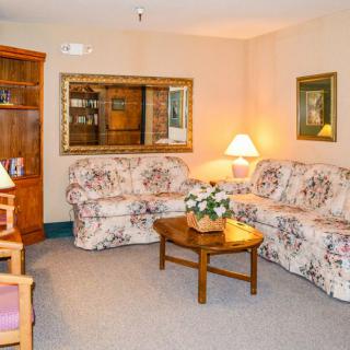 A cozy living room with floral sofas and warm lighting.