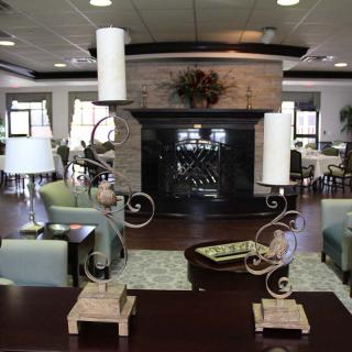 A spacious lounge area featuring modern decor with a central fireplace and stylish candle holders.