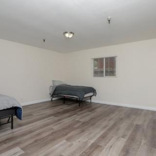 A minimalist room with two beds and wooden flooring.