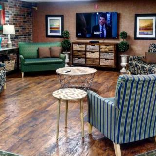 A cozy living room with stylish furniture and a wall-mounted TV.