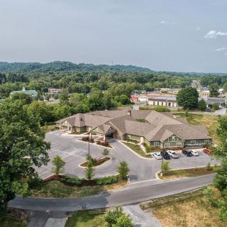 Aerial view of a building complex surrounded by trees and parking lots.