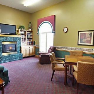 Cozy living room with a fireplace, bookshelf, and seating area.