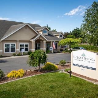 A well-maintained facility with a landscaped garden and clear signage on a sunny day.