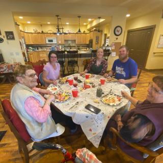 A family enjoying a meal together at a dining table in a cozy kitchen setting.
