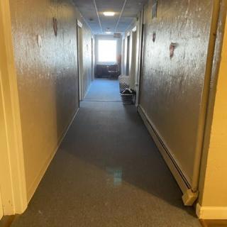 A well-lit hallway in a building with doors on each side.