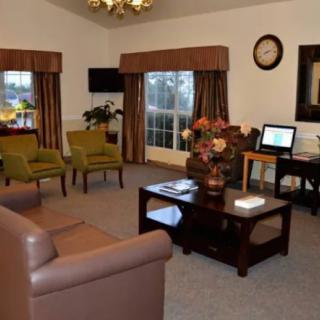 A cozy living room with comfortable seating, a coffee table, and a computer desk.