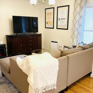A cozy living room with a modern sofa and a television setup.