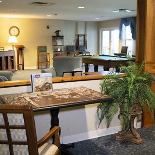 A cozy game room with a pool table, seating area, and decorative elements.