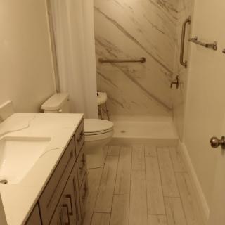 A modern, clean bathroom with a shower, sink, and toilet.