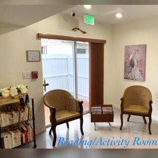 A cozy waiting room with chairs and a bookshelf.