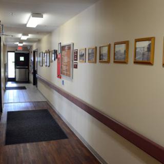 A well-lit hallway adorned with framed photographs on the wall.