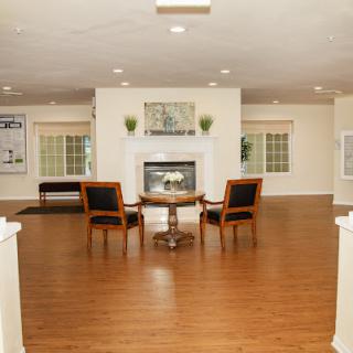 A spacious living room featuring elegant wooden flooring, cozy seating, and a welcoming fireplace.