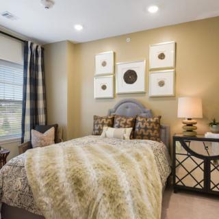 A cozy bedroom with stylish decor and artwork on the wall.