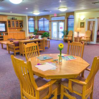 A cozy community room with wooden tables and chairs arranged for social gatherings.