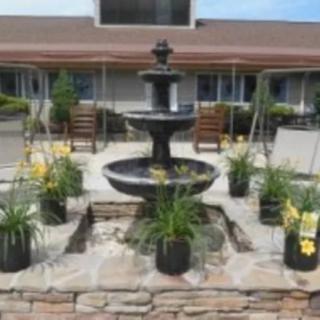 A decorative fountain surrounded by potted plants in a courtyard.