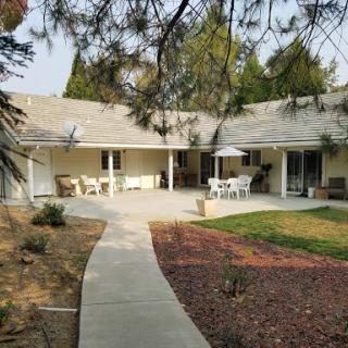 A serene view of a modern home with a welcoming patio and landscaped garden.