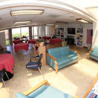 A spacious lounge area with sofas, tables, and a television.