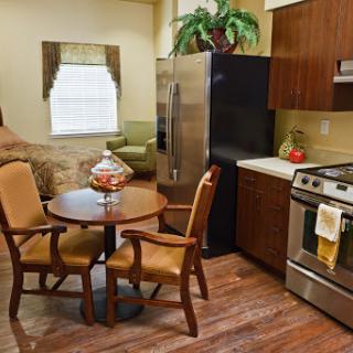A cozy kitchen area featuring modern appliances and a small dining setup.
