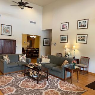 A cozy living room featuring comfortable seating, decorative artwork, and a warm atmosphere.