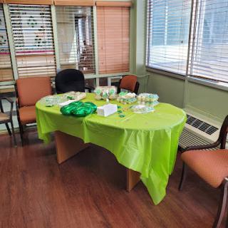 A colorful setup with a green tablecloth in an office environment, ready for an event.