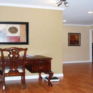 A neatly organized office space featuring a wooden desk and artwork on the walls.