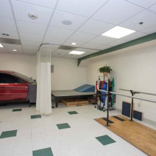 A physical therapy room equipped with a bed and various exercise equipment.