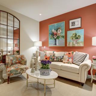 A beautifully designed living room featuring a mix of floral patterns, modern furniture, and vibrant wall art.