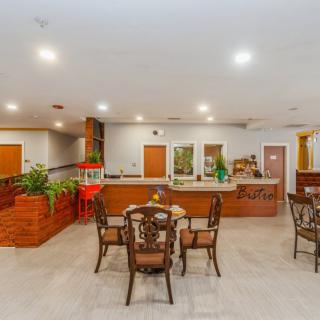 A spacious indoor dining area with elegant furnishings and plants.