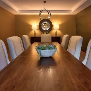 Elegant dining room with a long wooden table, comfortable chairs, and stylish lighting.