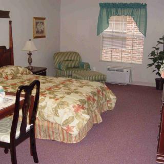 A cozy hotel room with a comfortable bed, armchair, and stylish furnishings.