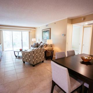 A modern, open-concept living and dining area featuring stylish furniture and neutral tones.